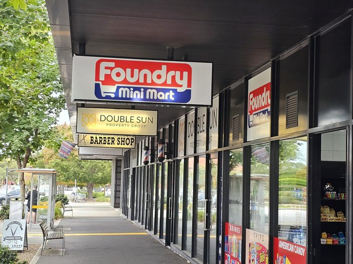 Foundry Mini Mart — Projecting lightbox sign catching passing trade along the shopping strip by Top1 Signs, Melbourne