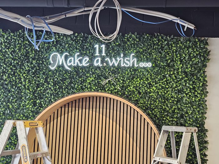 Make a Wish Neon — Custom LED neon sign mounted on a greenery wall feature by Top1 Signs, Melbourne