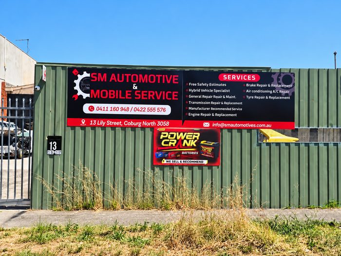 SM Automotive — Large printed sign fixed to the workshop fence listing mobile mechanical services by Top1 Signs, Melbourne